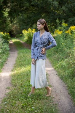 Güzel bir esmer yaz ormanı yolunda duruyor..