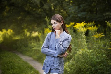 Güzel bir esmer yaz ormanı yolunda duruyor..