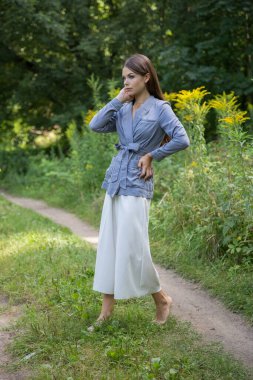 Güzel bir esmer yaz ormanı yolunda duruyor..