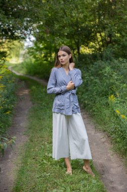 Güzel bir esmer yaz ormanı yolunda duruyor..