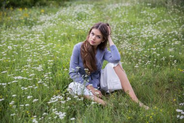 Güzel bir esmer yaz çayırında oturur.