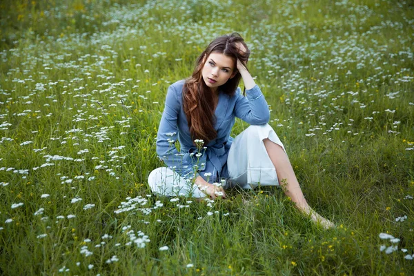 Güzel bir esmer yaz çayırında oturur.
