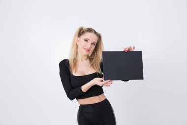 Siyah elbiseli güzel bir sarışın elinde siyah bir kağıt tutuyordu..