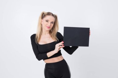 Siyah elbiseli güzel bir sarışın elinde siyah bir kağıt tutuyordu..