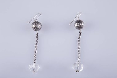 Açık gri arka planda güzel küpeler. Kostüm mücevherleri. 