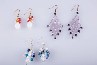 Açık gri arka planda güzel küpeler. Kostüm mücevherleri. 