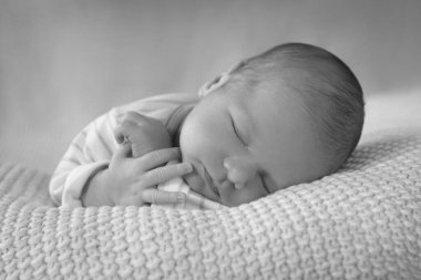 Bebek yumuşak bir battaniyenin üzerinde uyuyor..