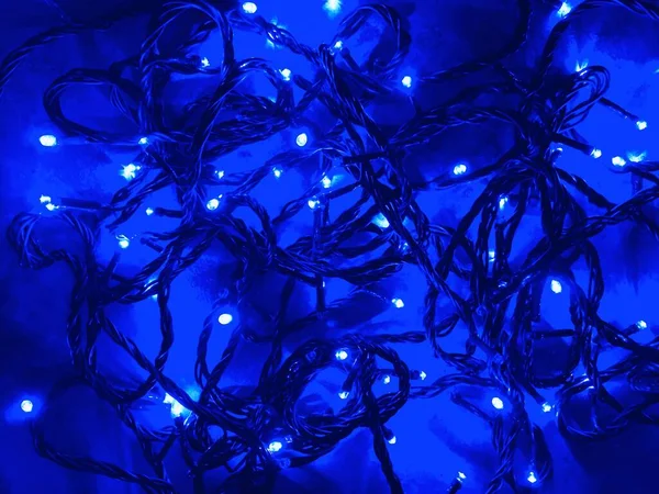 Mavi soyut yüzey arka planında bulanık / bokeh efektli Noel çelengi.