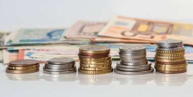 Farklı para birimlerinin para ve banknotları beyaz zemin üzerinde yansıma ile