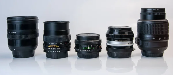 Beyaz arkaplanda yansımalı eski ve modern fotoğraf merceği seti