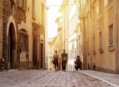 Ortaçağ 'da dar bir kaldırım taşı caddesinde yürüyen iki turist.