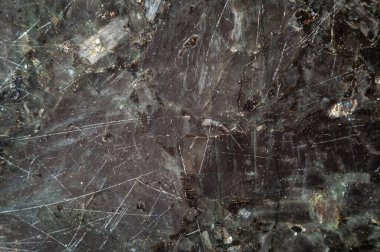 Texture of natural polished scratched  black labradorite stone. Abstract background.