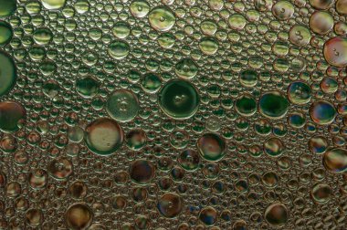 Abstract background and texture of oil drops on water with different colors