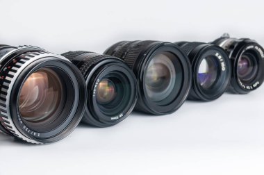 Beyaz arkaplanda modern ve eski DSLR kamera lensi seti