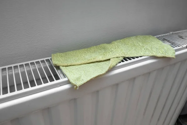 Toallita amarilla, secado de tela de microfibra en un radiador de calefacción central después de limpiar la casa —  Fotos de Stock