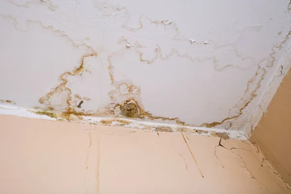 Rain water leaks on the ceiling because of damaged roof causing decay, peeling paint and moldy — Stock Photo, Image