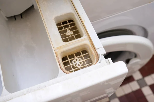 Dirty moldy washing machine detergent and fabric conditioner dispenser drawer compartment close up. Mold, rust and limescale in washing machine tray. Home appliances periodic maintenance — Stock Photo, Image