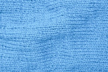 Buruşuk mavi kumaş arka plan, dalgalı ve bükülmüş, kıvrımlı turkuaz yün örgü