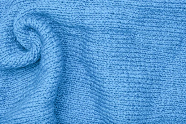 Gekromde gebreide blauwe stof achtergrond, gegolfd en gedraaid, gebogen turquoise wollen gebreide kleding — Stockfoto