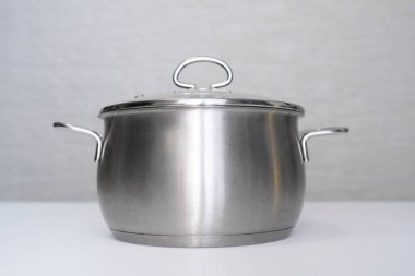 Paslanmaz çelik tencere, beyaz masada saksı, zararsız çevre dostu mutfak aletleri, insanlar için zararsız.