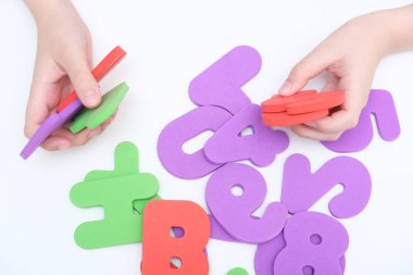 Bir çocuğun elleri, eğitim sırasında renkli sayılar tutan bir çocuk, matematik öğreniyor.