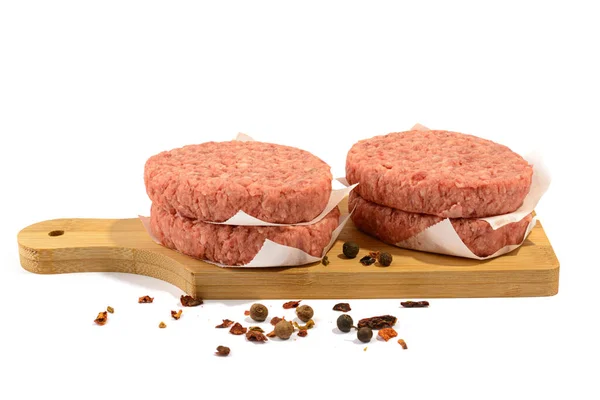 Tortas de carne cruda para una hamburguesa.Enfoque selectivo.Aislado sobre un fondo blanco. — Foto de Stock