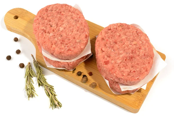 Empanadas de carne cruda para hacer una hamburguesa.Aislado sobre un fondo blanco.Enfoque selectivo. — Foto de Stock