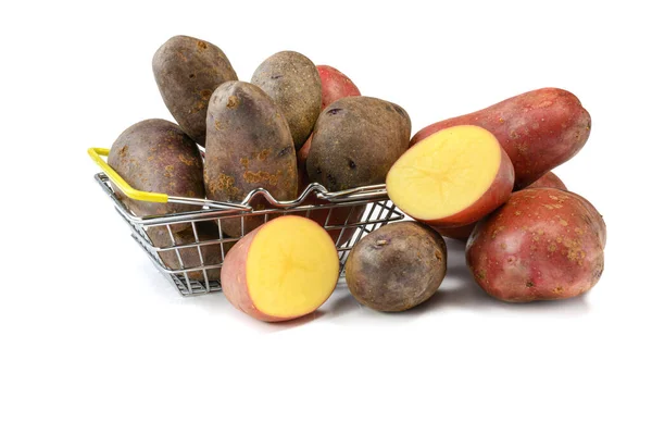Raw rosa inteiro e cortar tubérculos de batata em uma cesta de compras em um fundo isolado branco.Batatas na pele. — Fotografia de Stock