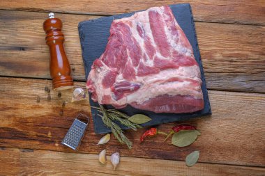 Çiğ domuz pirzolası. Servis panosundaki et malzemesinin en iyisi. kapat. Seçmeli Odaklanma