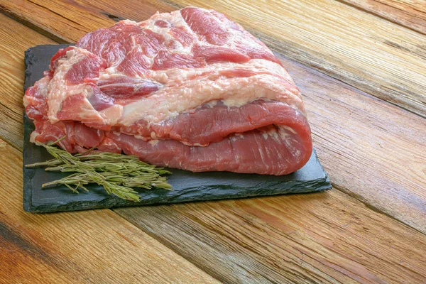 Côtes de porc crues. Garnir l'ingrédient de viande sur une plaque de service en ardoise. close-up Focus sélectif — Photo