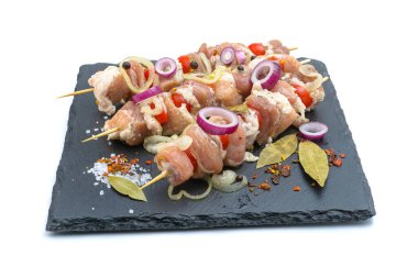 Biber, soğan, körfez yapraklı çiğ domuz şiş kebabı. Pişirmeye hazır domuz kebabı, ızgara, beyaz bir arka planda izole edilmiş..