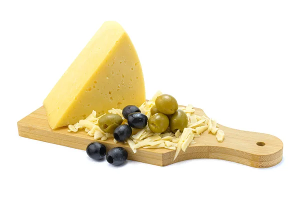 Fatia de queijo amarelo duro e ralado com azeitonas e azeitonas em uma tábua de madeira, close-up, isolado em um fundo branco.Foco seletivo. — Fotografia de Stock