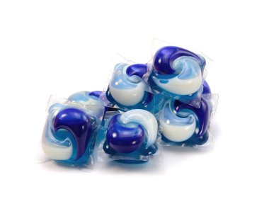 Beyaz arka planda izole edilmiş mavi ve beyaz toz ve jel kaplı çamaşır kapsülleri. Çamaşır ve temizlik işleri. Üst görünüm.