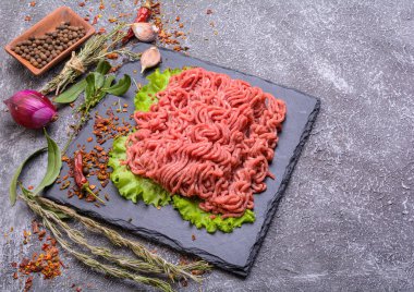 Sarımsak, kırmızı biber ve dereotla süslenmiş taze kıyma ve domuz eti. Koyu doku arka planı. Düz plan..