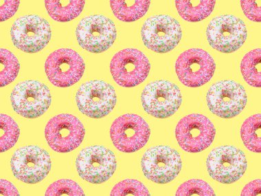 Parlak renkli serpiştirilmiş, sarı arka planda izole edilmiş donutlar.