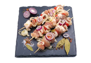 Salamurada çiğ şiş kebap, biber, soğan, körfez kebabı. Domuz kebabı, pişirmeye hazır, barbekü, beyaz bir arka planda izole edilmiş. Yatay görüş..