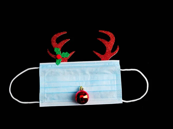 Cerrahi maske ve Noel süslemeleriyle yapılmış Noel geyikleri