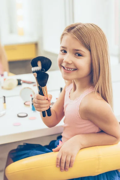 Little girl holding make-up brushes — Stock Photo, Image