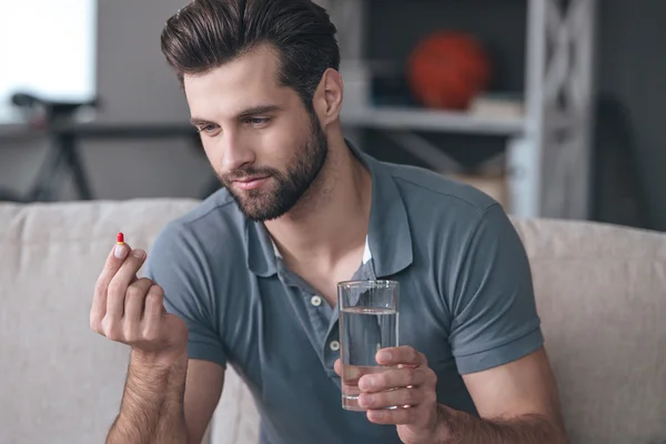 Man holding a glass of water  and pill — Stock Photo, Image