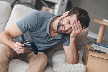Çaresiz genç adam joystick tutan