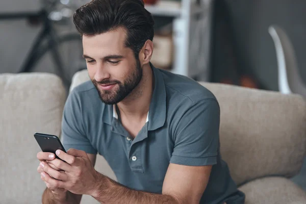 Ung man med sin smarta telefonen — Stockfoto