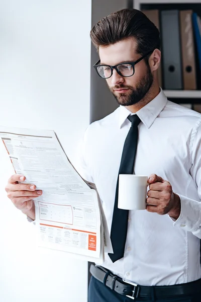 Бизнесмен в очках читает газету — стоковое фото