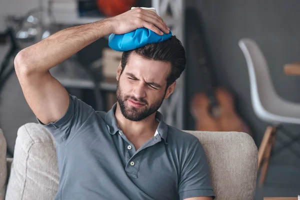 Man holding ice bag on his head — Stok fotoğraf