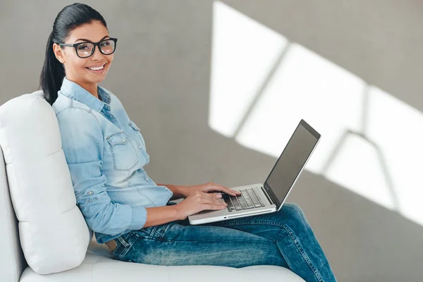 Женщина в очках, работающая на ноутбуке — стоковое фото