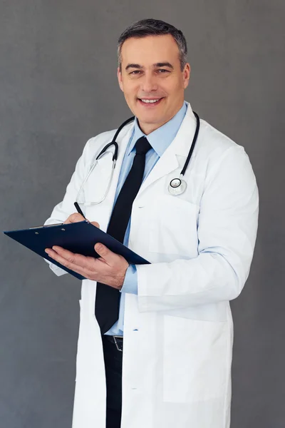 Médico maduro con portapapeles — Foto de Stock
