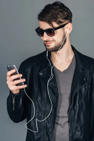 Человек в наушниках со смартфоном — стоковое фото