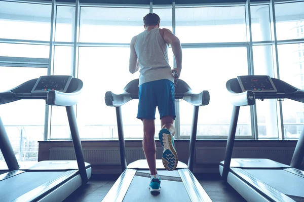 Junger Mann auf Laufband — Stockfoto