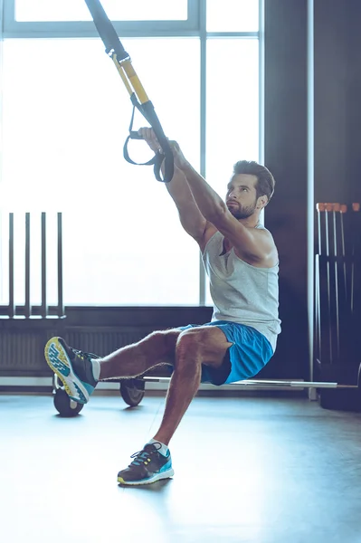 Hombre joven haciendo ejercicio en el gimnasio — Foto de Stock