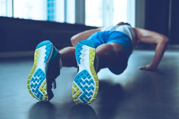 Jovem fazendo push-up no ginásio — Fotografia de Stock