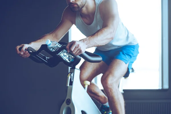 Young man  cycling at gym — Stock Photo, Image